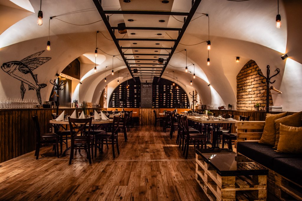 Wide view of Fricska Gastropub dining room with arched ceiling and warm lighting in Budapest.