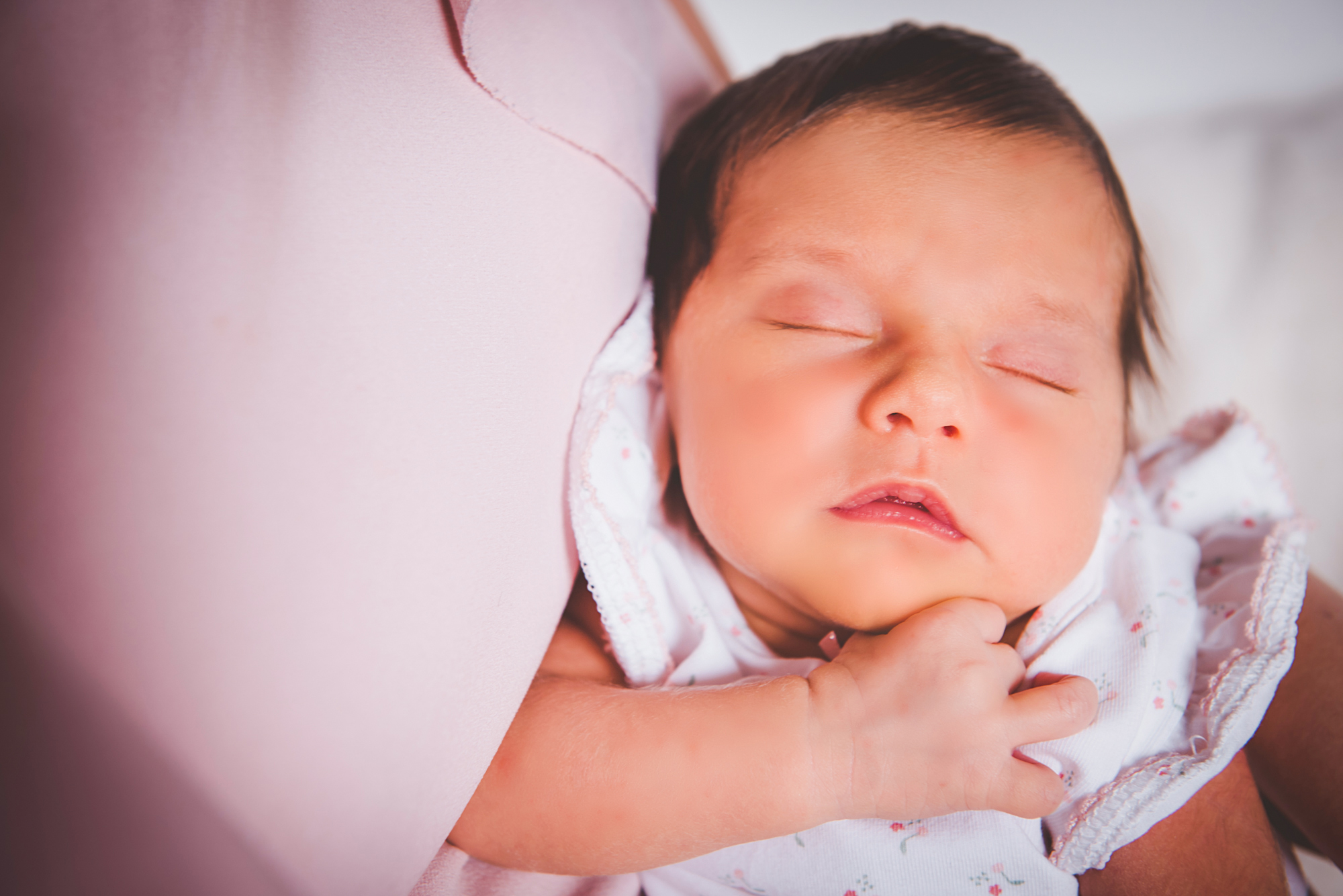 Sleeping newborn baby resting peacefully on soft blanket during quiet home newborn session.