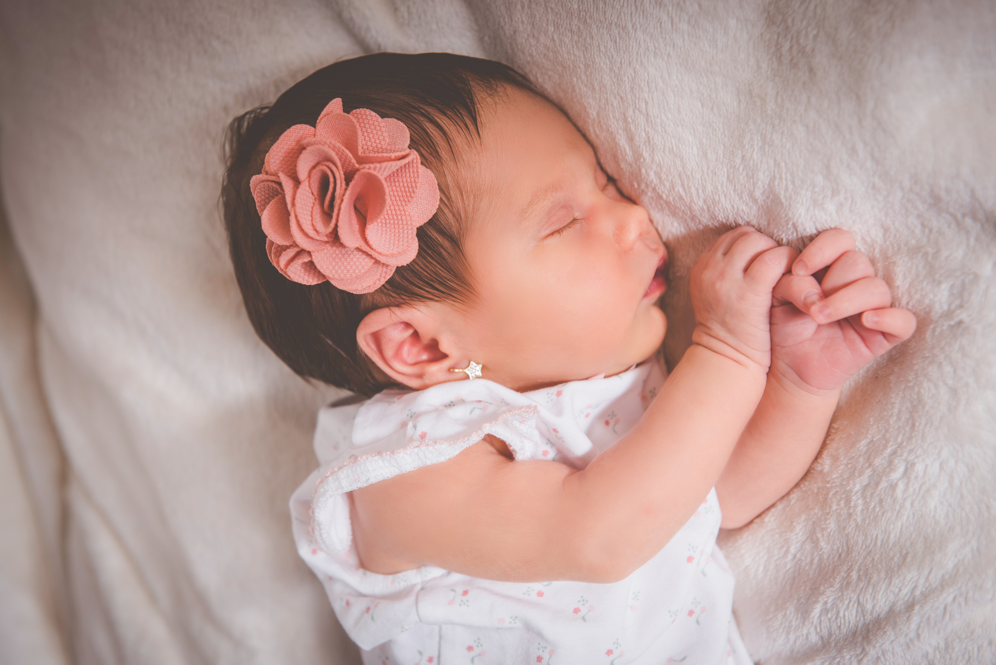 Sleeping newborn baby resting peacefully on soft blanket during quiet home newborn session.