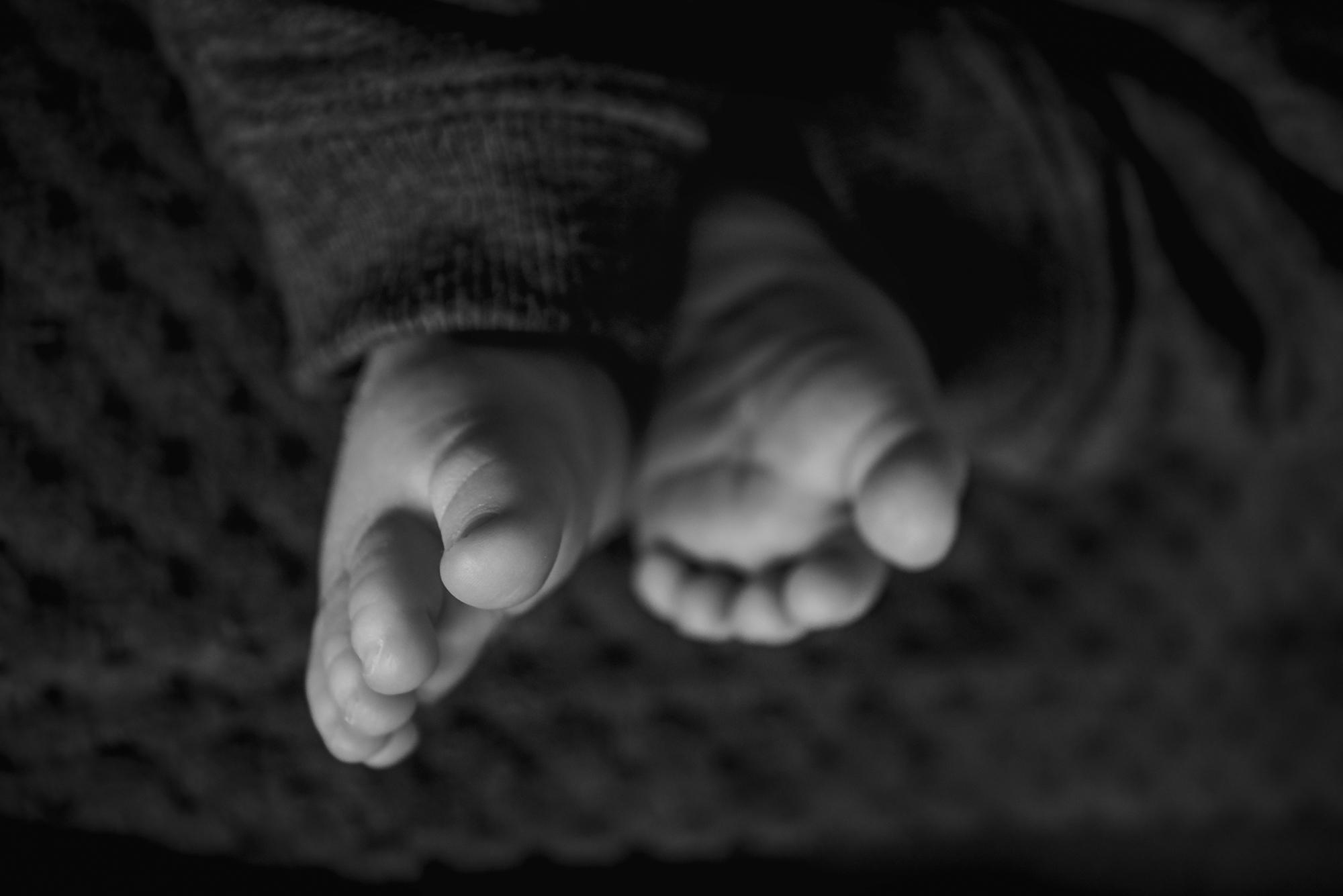 Soft close-up of tiny newborn feet during a lifestyle newborn session.