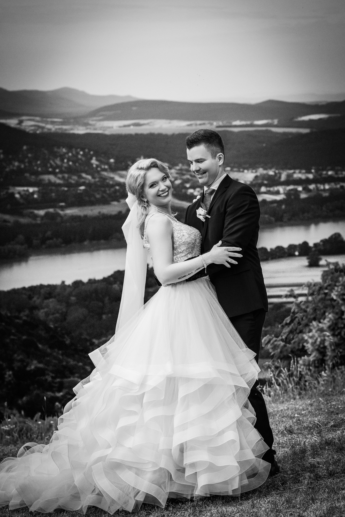 Black and white couple portrait smiling with Danube river and hills behind.