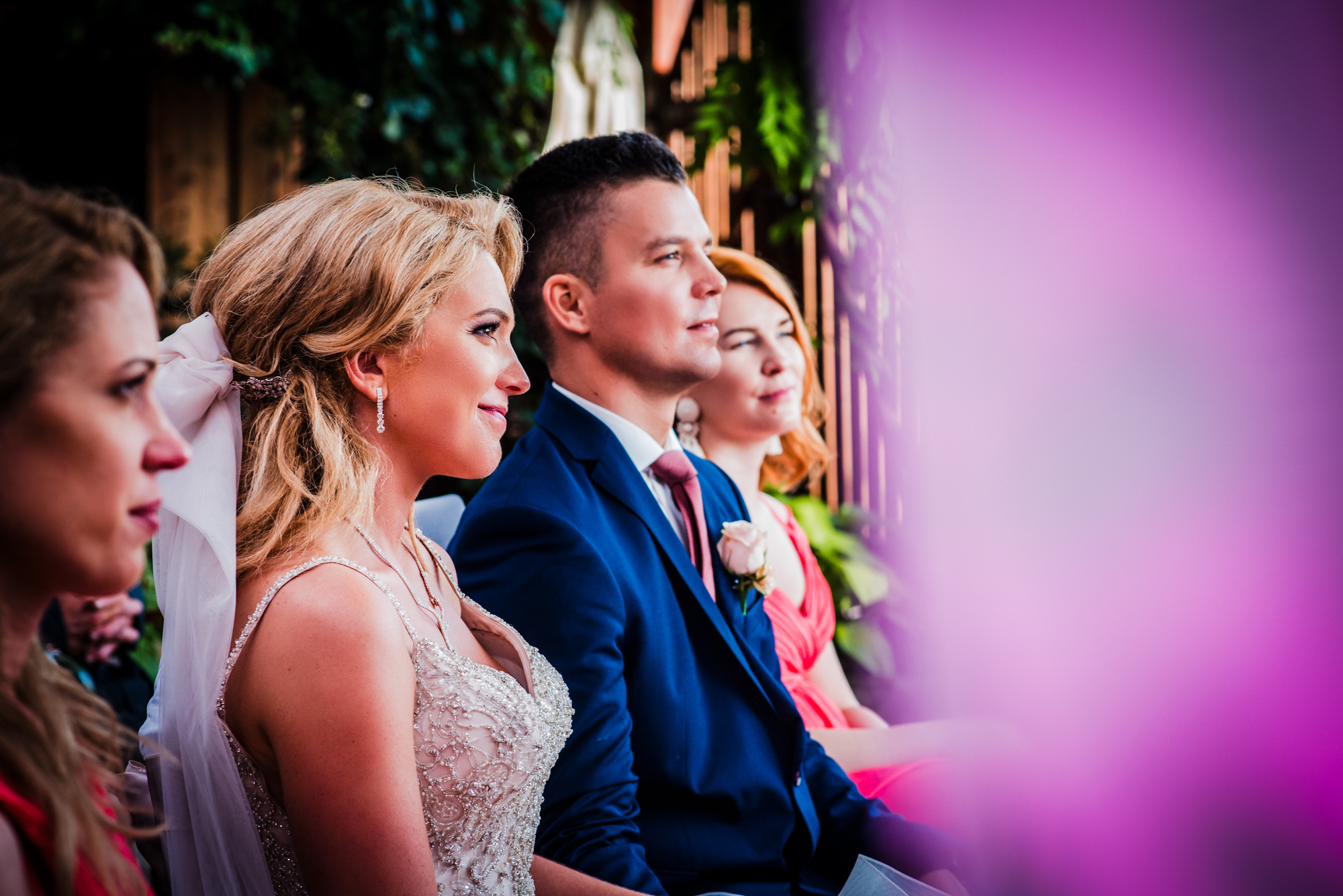 Side view of bride and groom listening during emotional outdoor wedding ceremony.