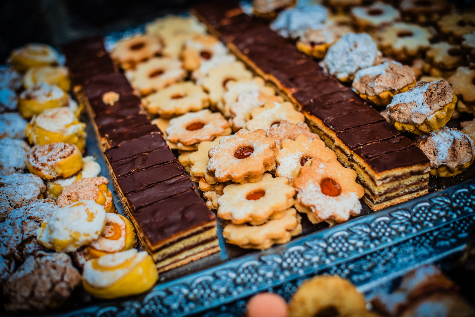 Selection of traditional pastries and desserts arranged on decorative tray at wedding reception.