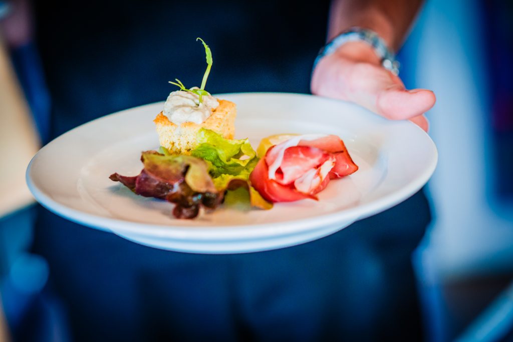 Plated gourmet starter served at wedding reception with garnish and salad.