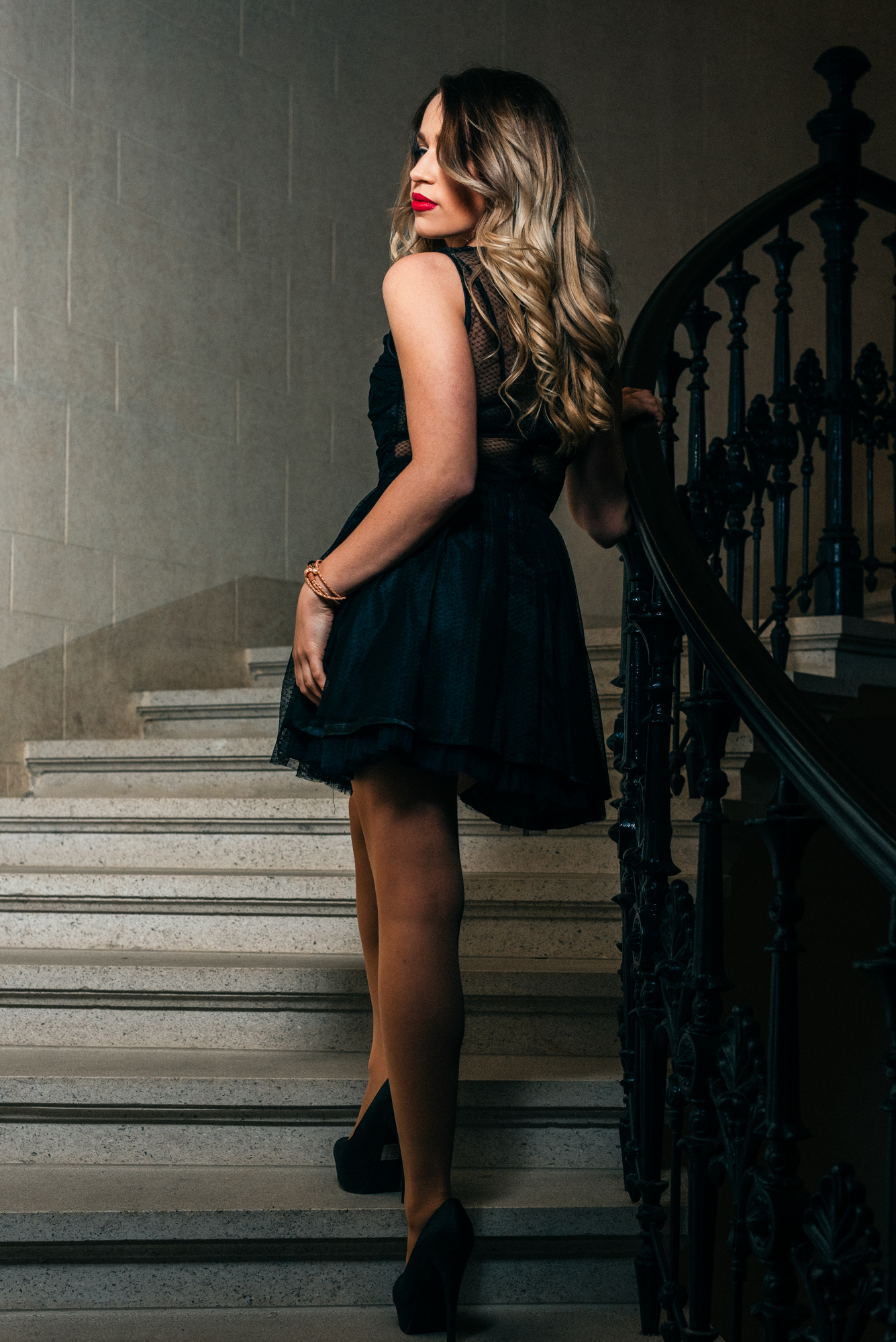 Side profile portrait on staircase with textured black dress.