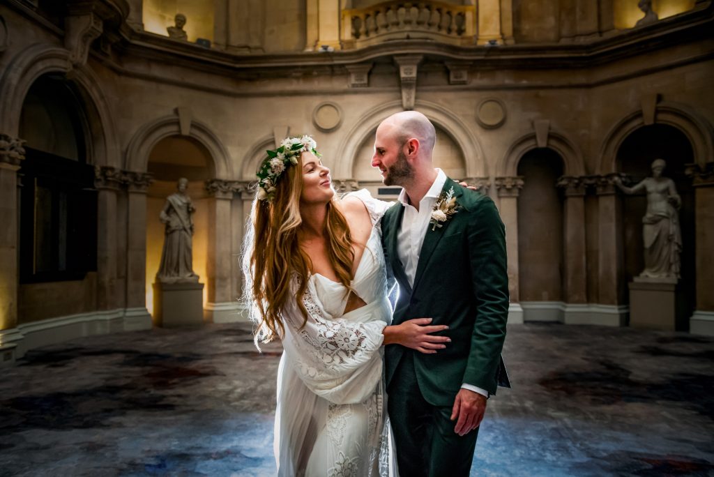 Bride and groom embracing inside Bristol Marriott Royal Hotel with dramatic light and stone architecture.