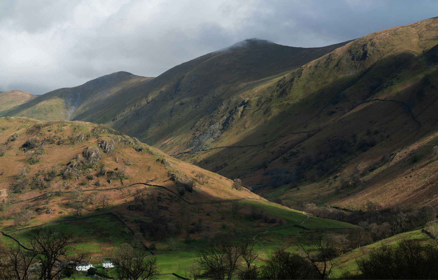 Sunlight and shadows across the rugged Lake District mountains in England, a romantic destination for eloping in the UK.