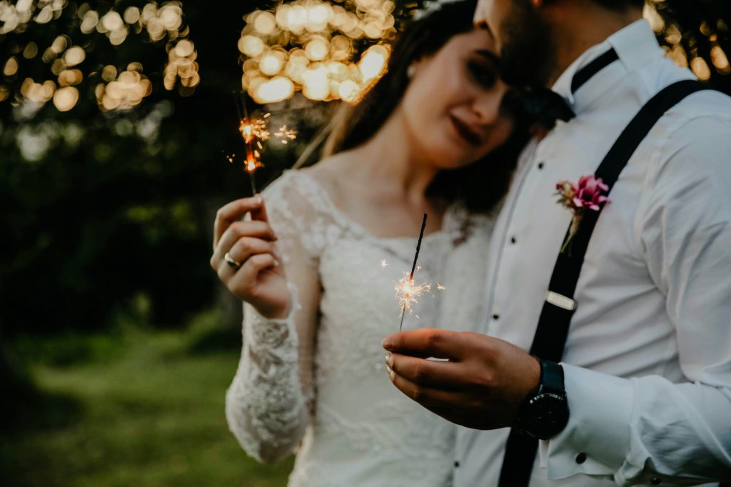 Bride and groom holding sparklers together during a winter evening wedding celebration.