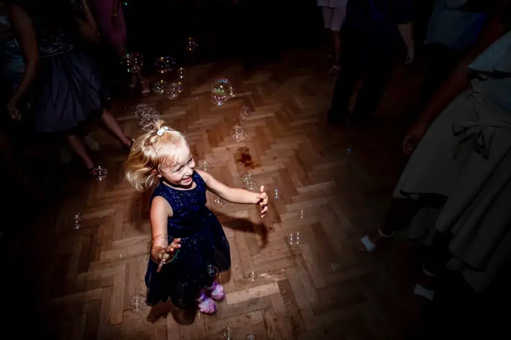 Candid moment of child playing with bubbles captured by Bristol family photographer during event