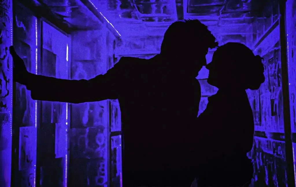 Silhouette couple sharing an intimate moment under purple neon light captured by wedding photographer Bristol