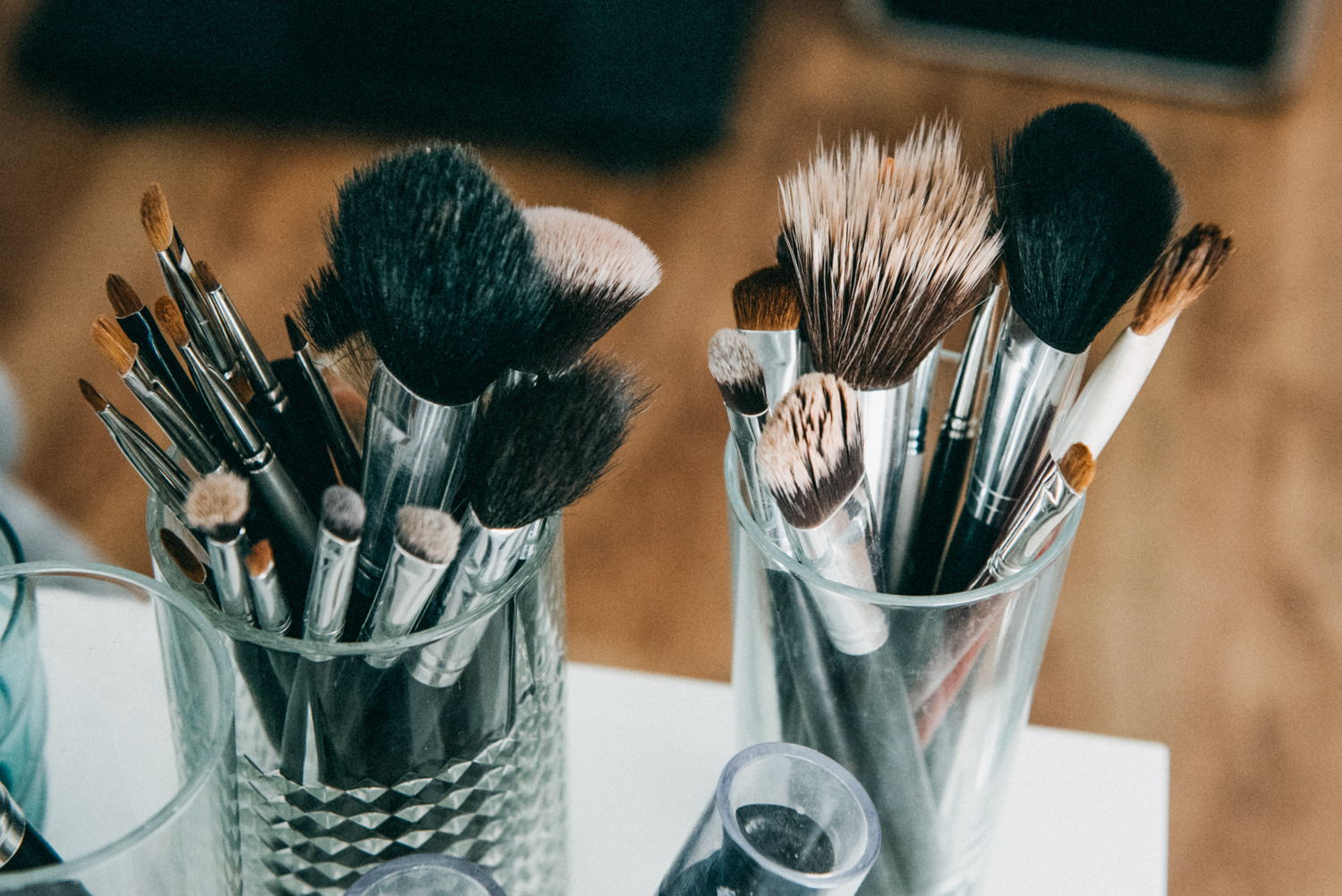 Makeup accessories such as make up brushes within glass containers as part of a wedding emergency kit.