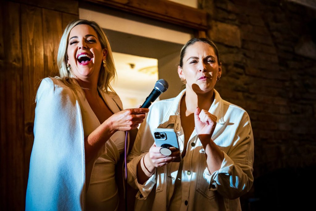 Two guests are doing their wedding speeches during an evening wedding reception.