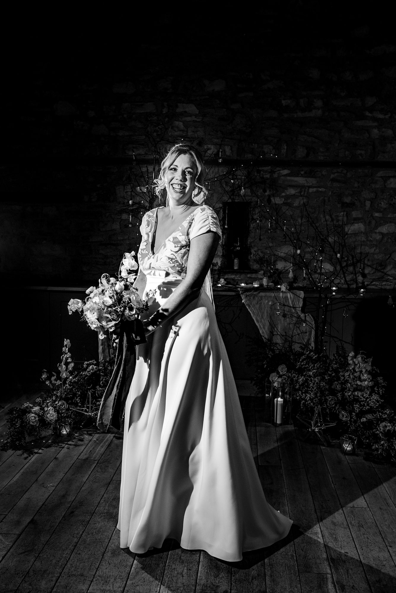 Bride laughing while holding her bouquet under dramatic light during the Starry Night editorial.