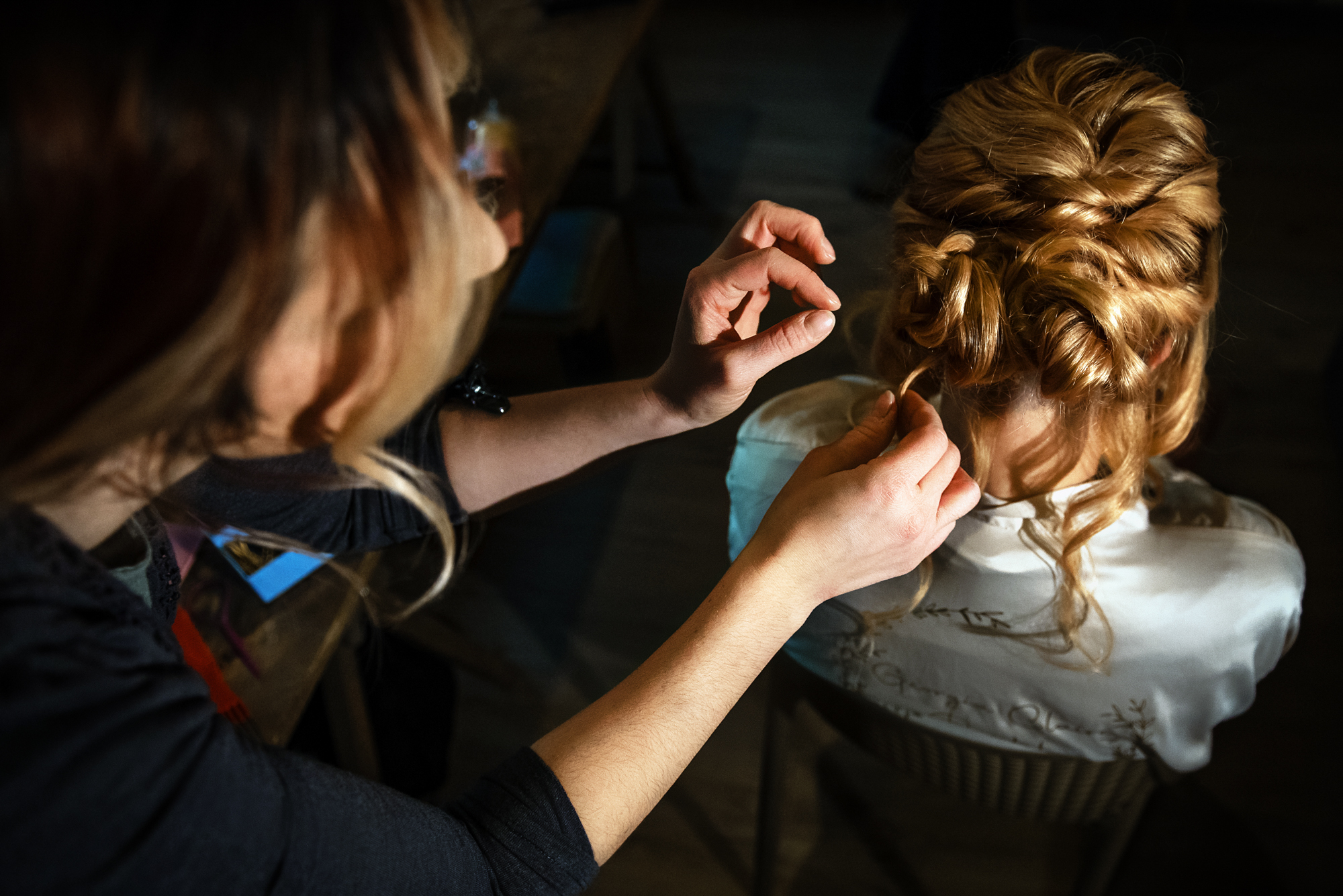 Bridal updo being secured with careful hands during the winter wedding editorial.