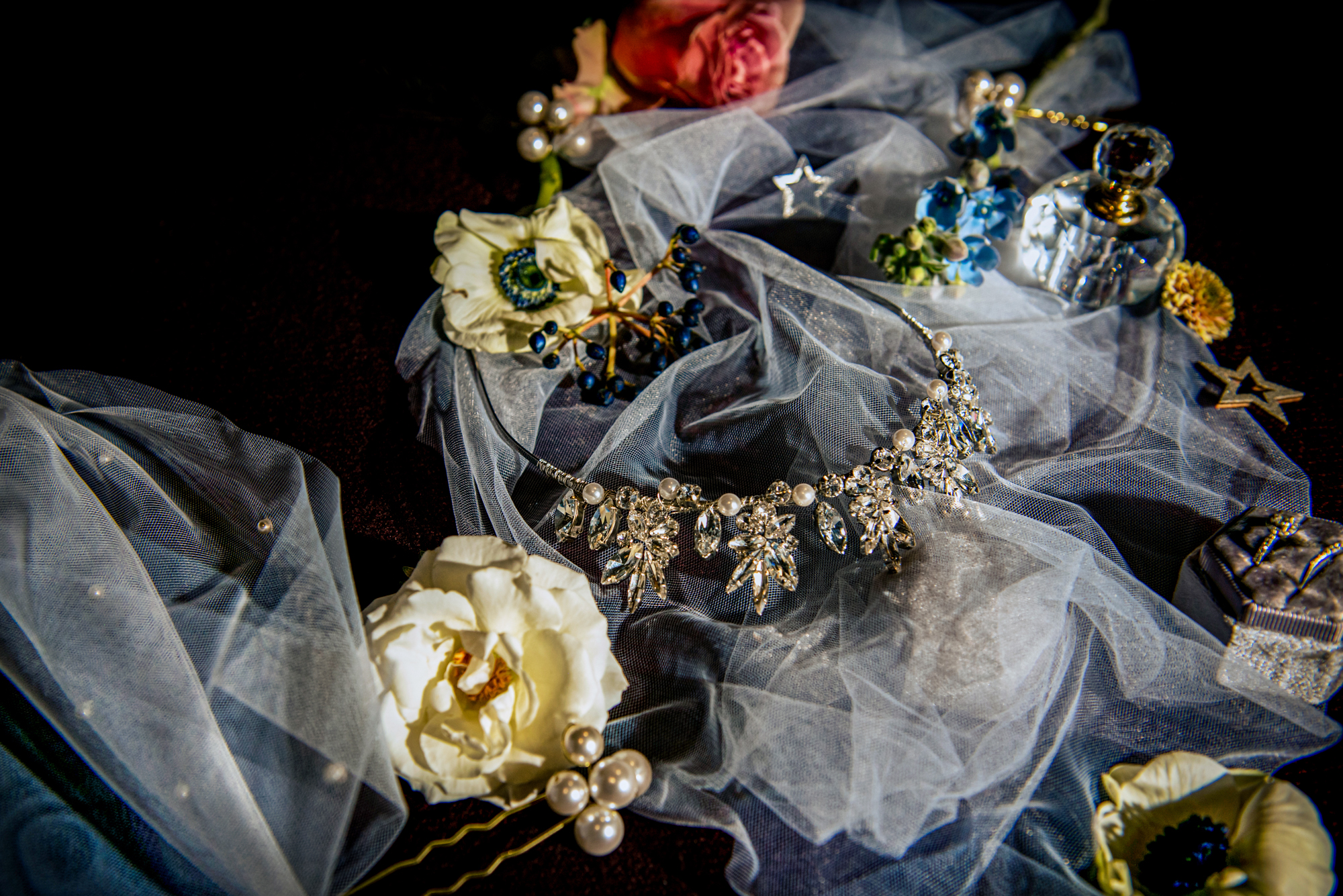 Crystal bridal necklace styled on soft tulle with winter florals and pearl hairpins.