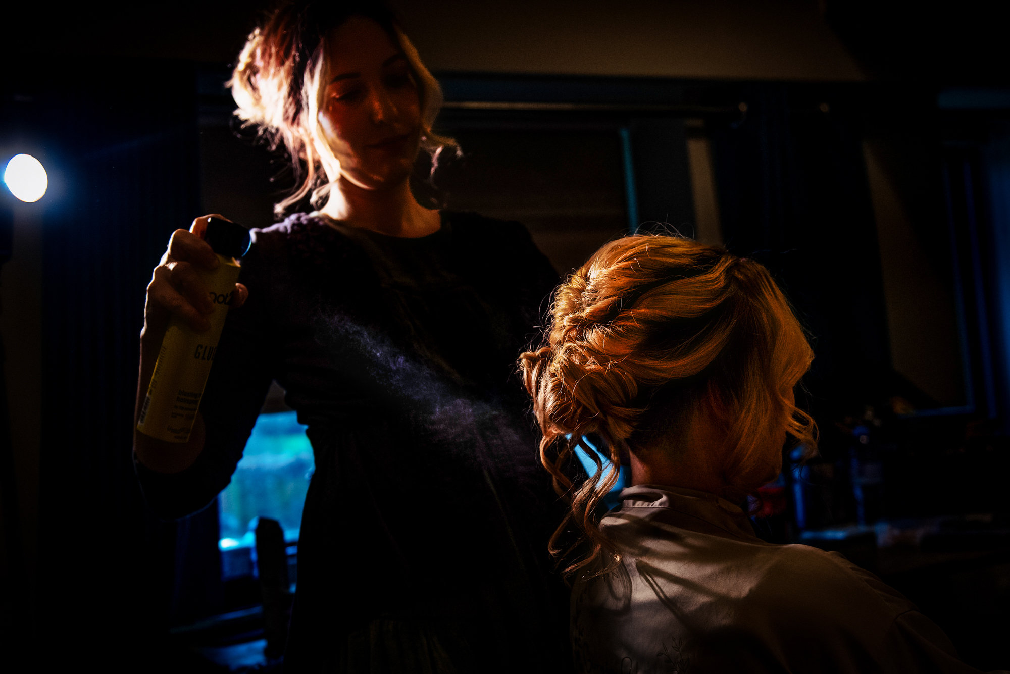 Finishing touches on the bride’s textured updo captured in warm Folly Farm light.