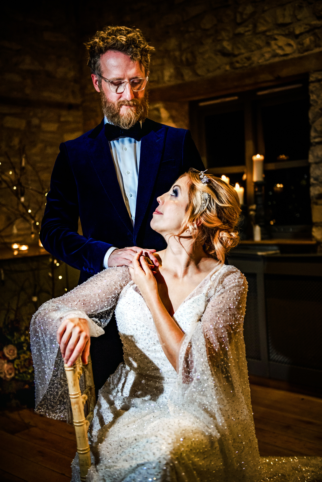 Groom standing behind the bride as she holds his hand during the winter editorial.