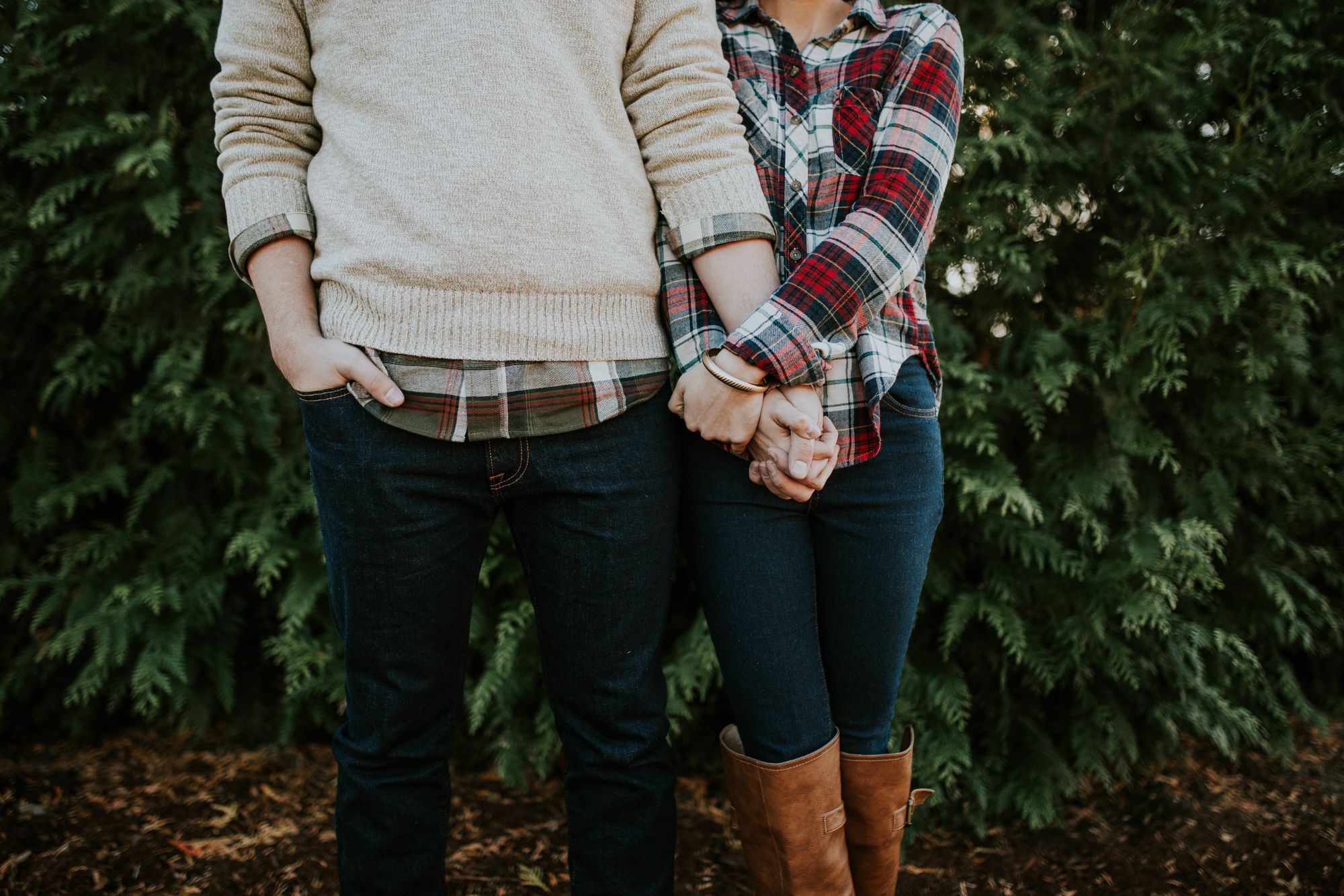 Couple holding hands in coordinated outfits during a relaxed nature couple photoshoot.