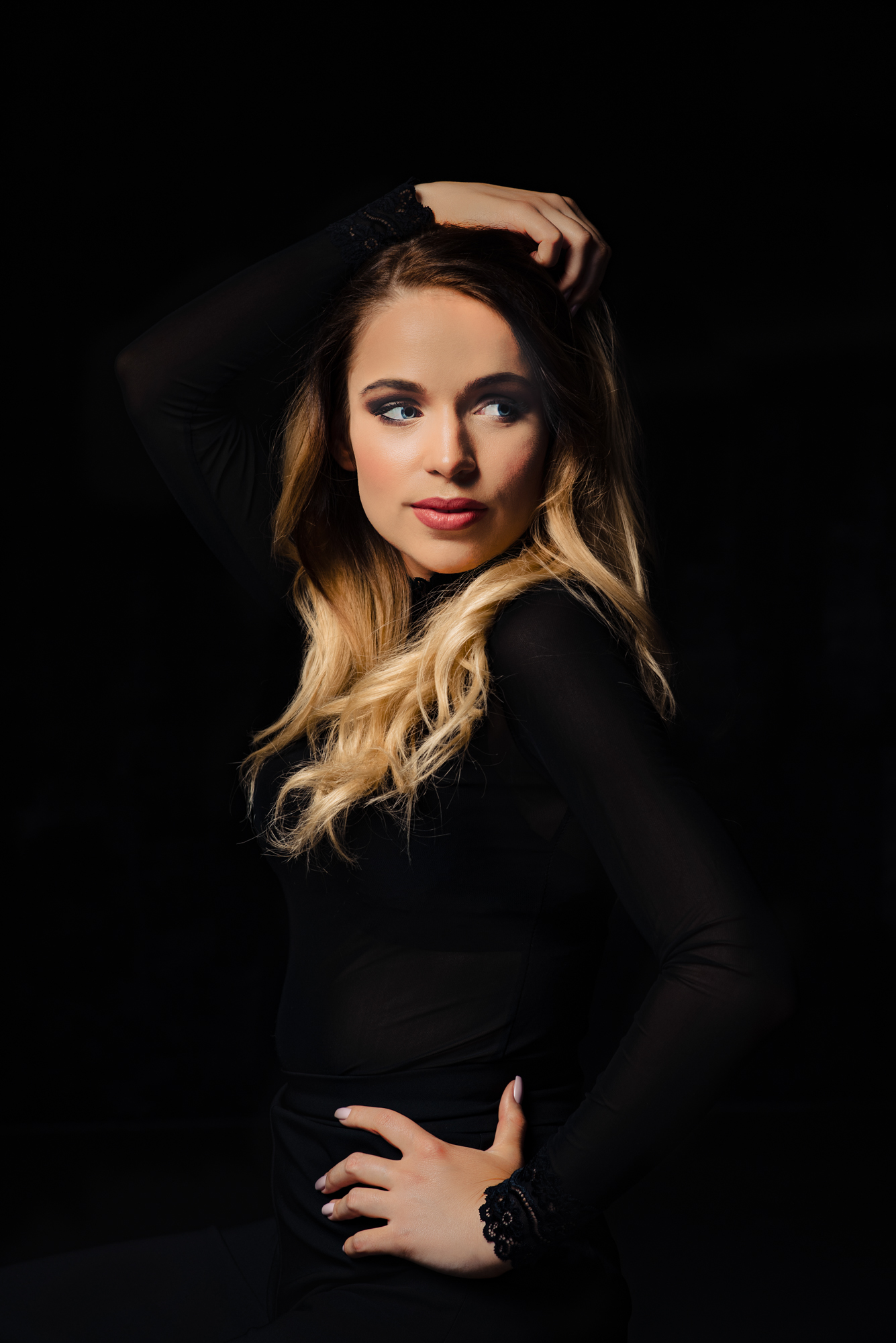 Studio portrait session looking away in dramatic low-key light.