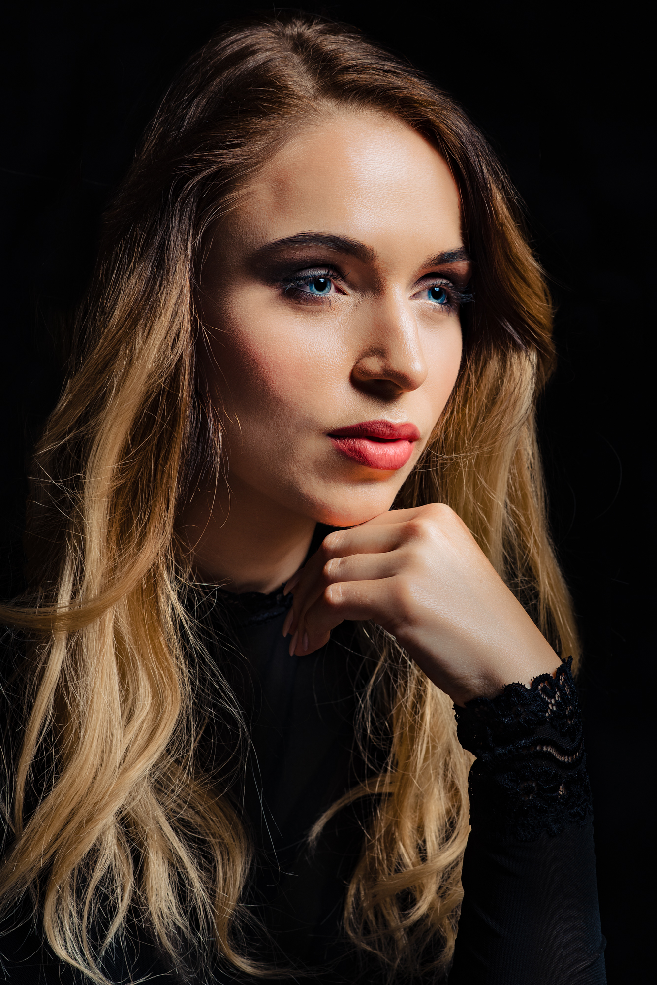 Close-up studio portrait of a woman with blue eyes and soft directional light.
