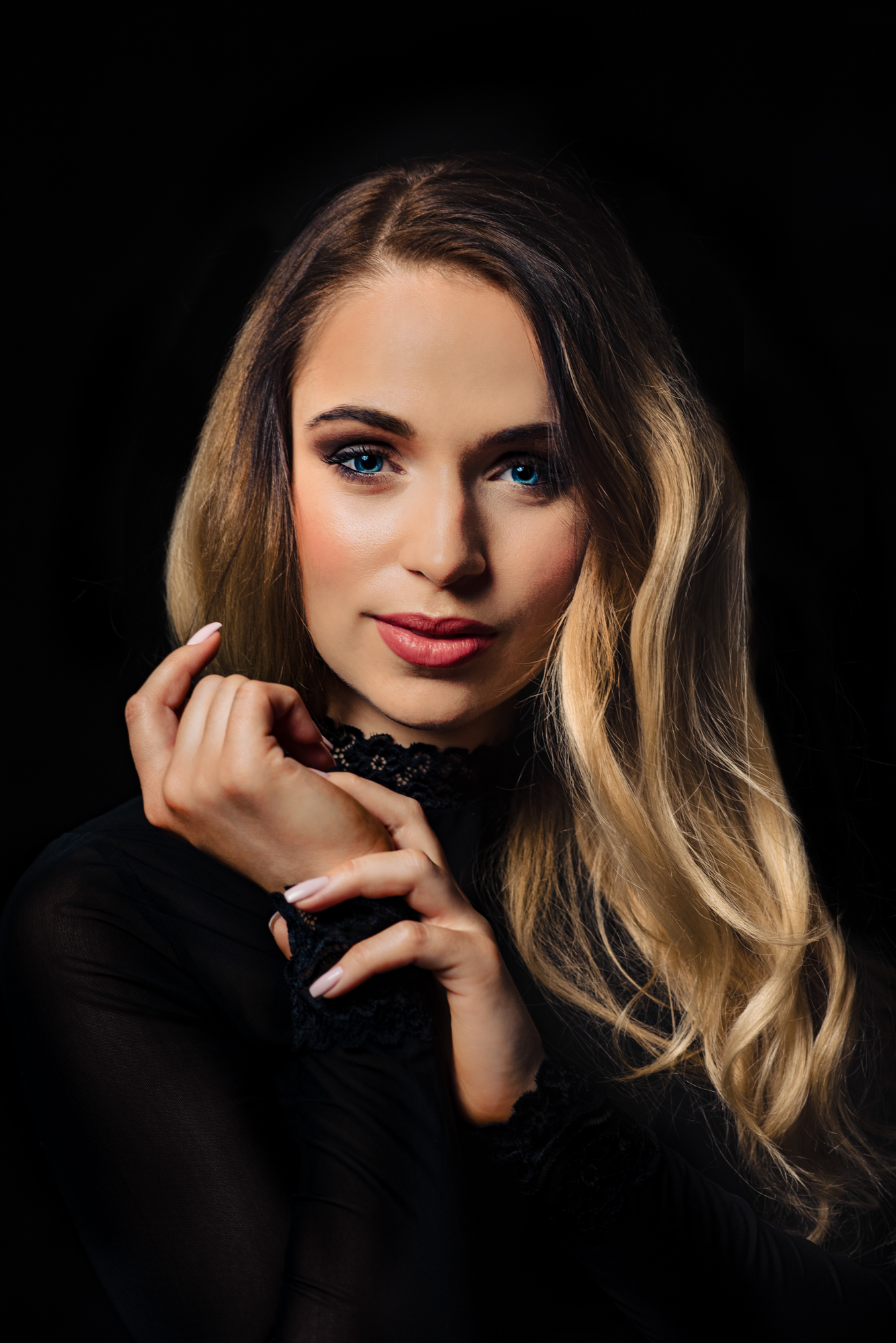 Beauty portrait from a studio portrait session with hands near her face.