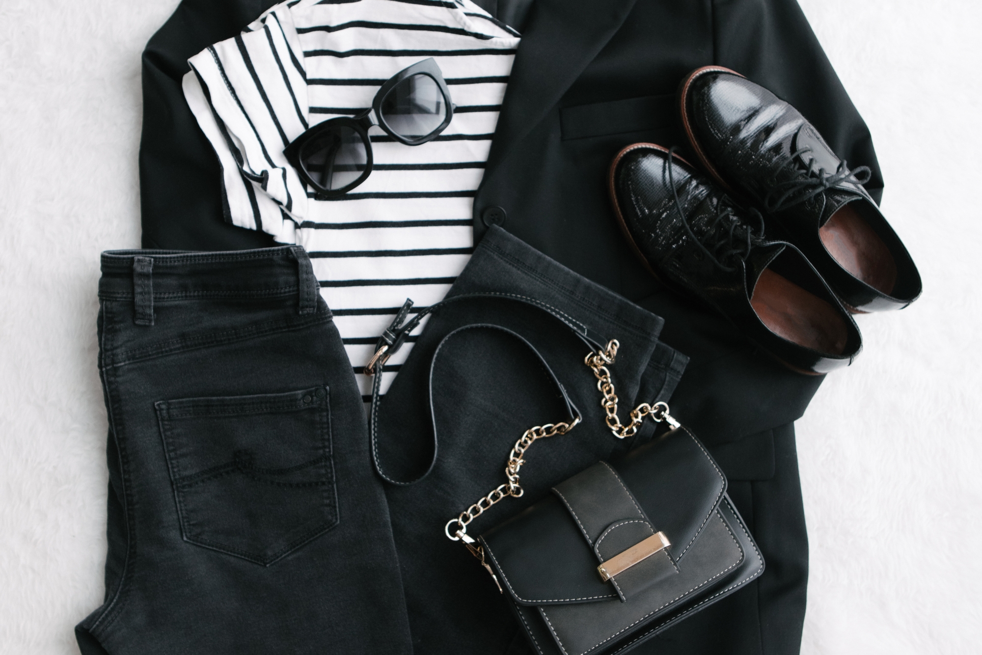 Flat lay showcasing practical outfit ideas for what a wedding photographer might wear on the wedding day.