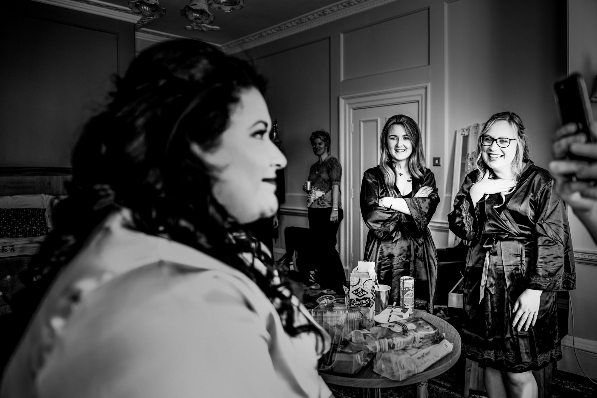 Bride looking emotional while friends watch during getting ready at Arnos Manor Hotel wedding.