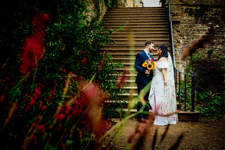 Close-up of bride’s bouquet with sunflowers and red roses during Bristol wedding at Ashton Court.