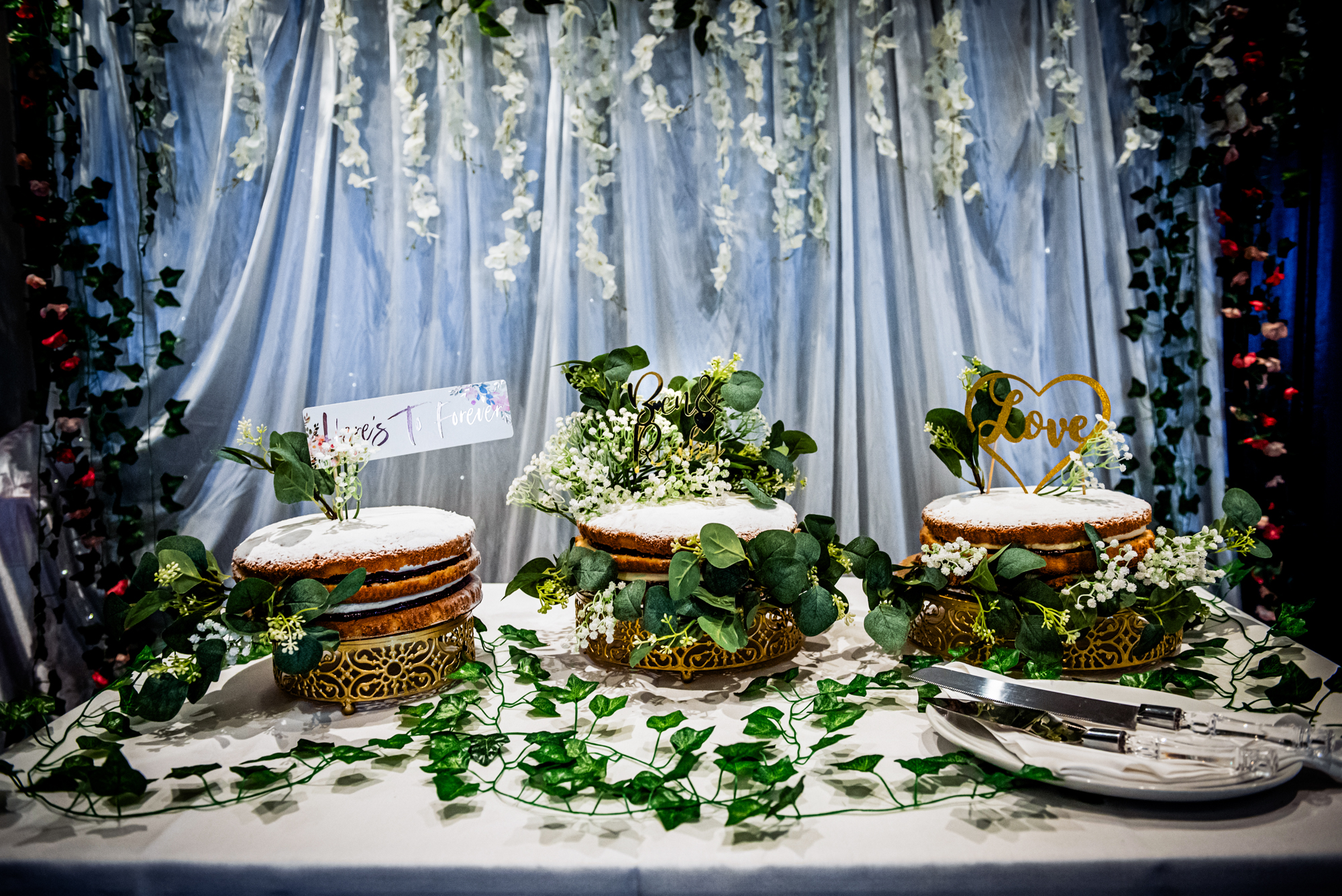 Close-up of three wedding cakes with foliage decoration at Arnos Manor Bristol reception.