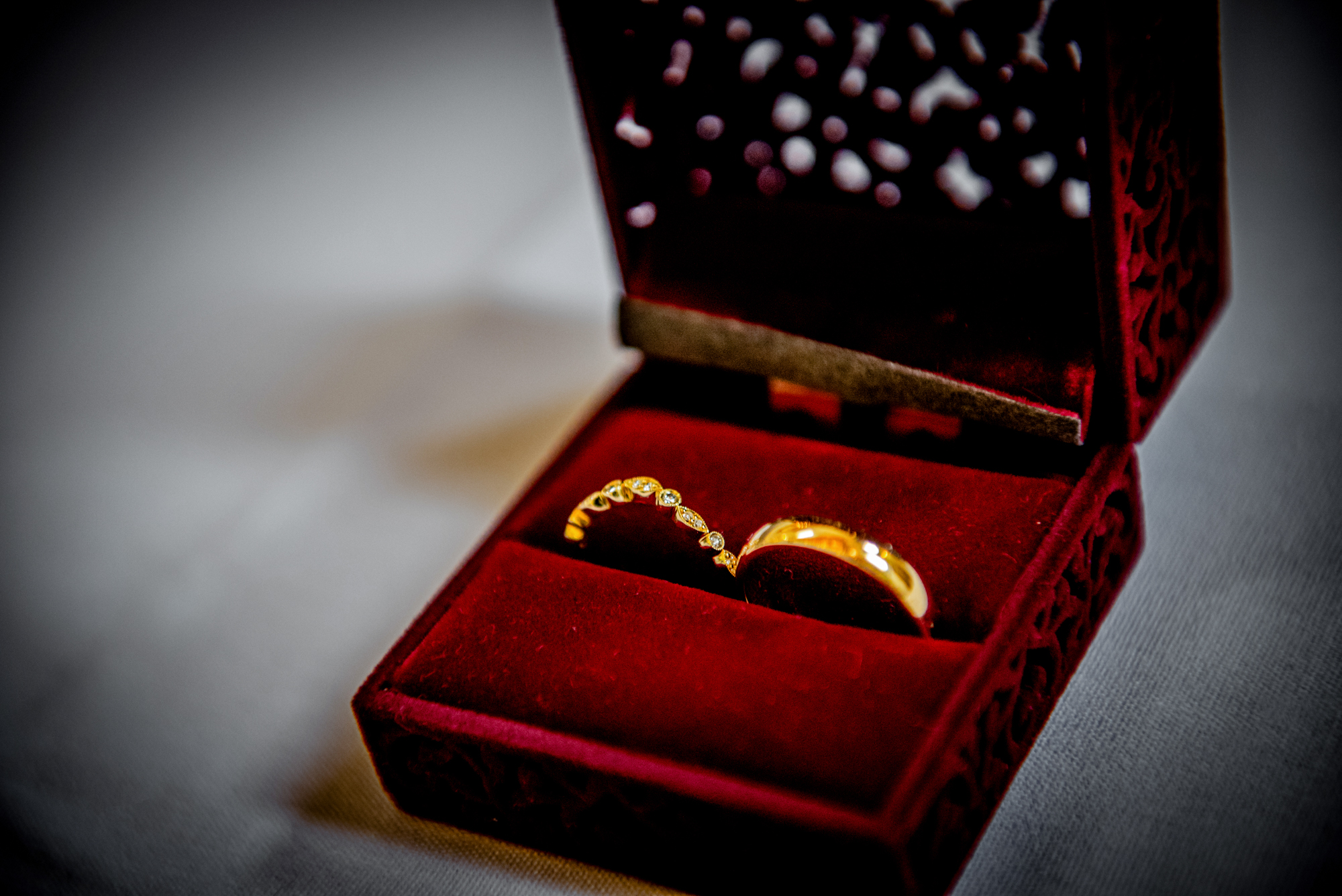 Close-up of wedding rings in red velvet box.