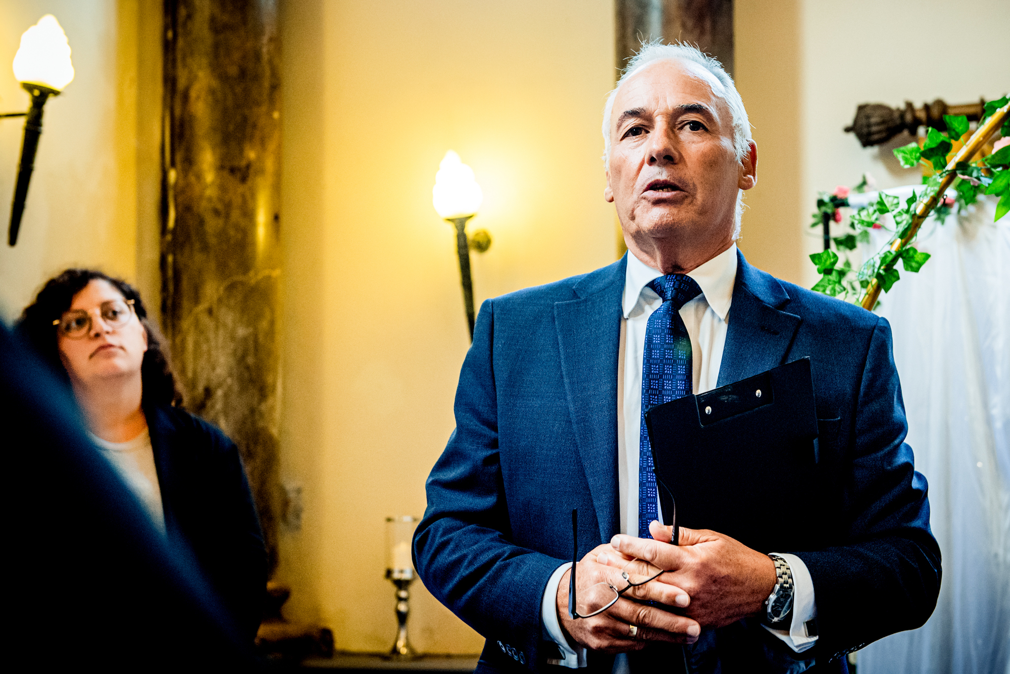 Wedding officiant speaking during ceremony at Arnos Manor Hotel in Bristol indoor wedding venue.