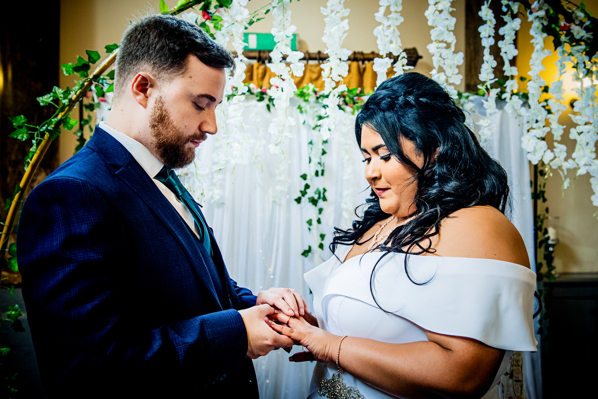 Groom placing wedding ring on the bride's finger during ceremony at Arnos Manor Bristol.