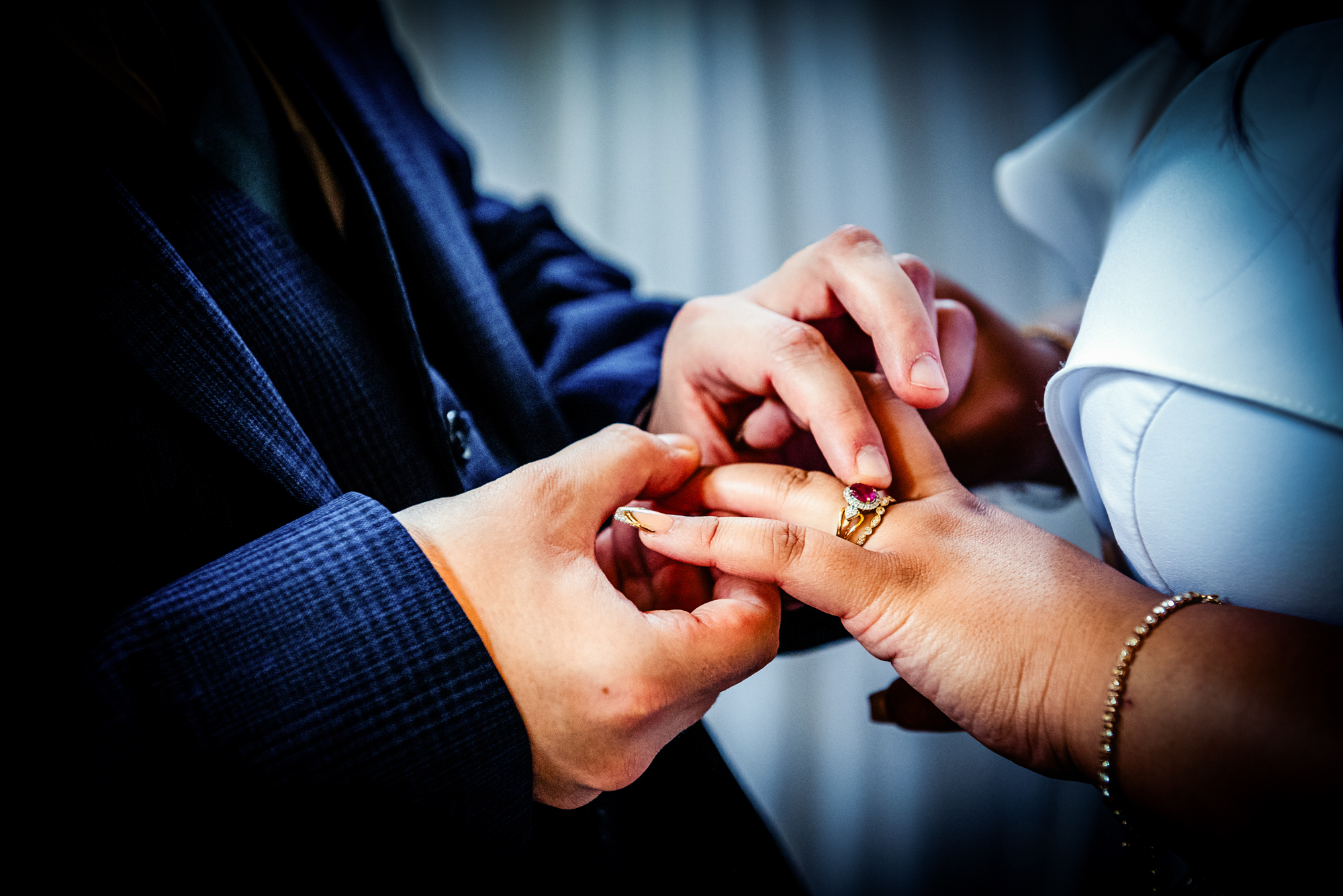 Close-up of groom placing ring on bride’s hand during Arnos Manor ceremony.