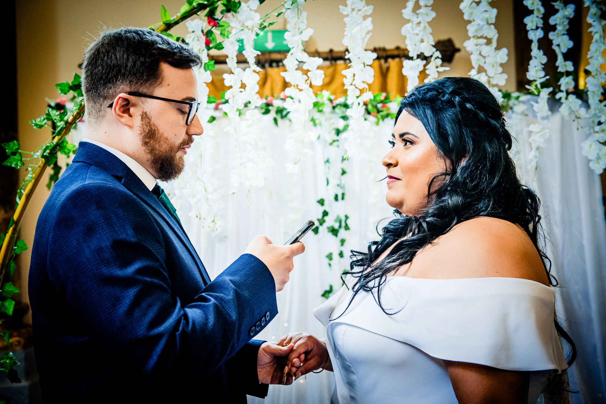 Groom reading vows from phone during ceremony at Arnos Manor Bristol wedding.