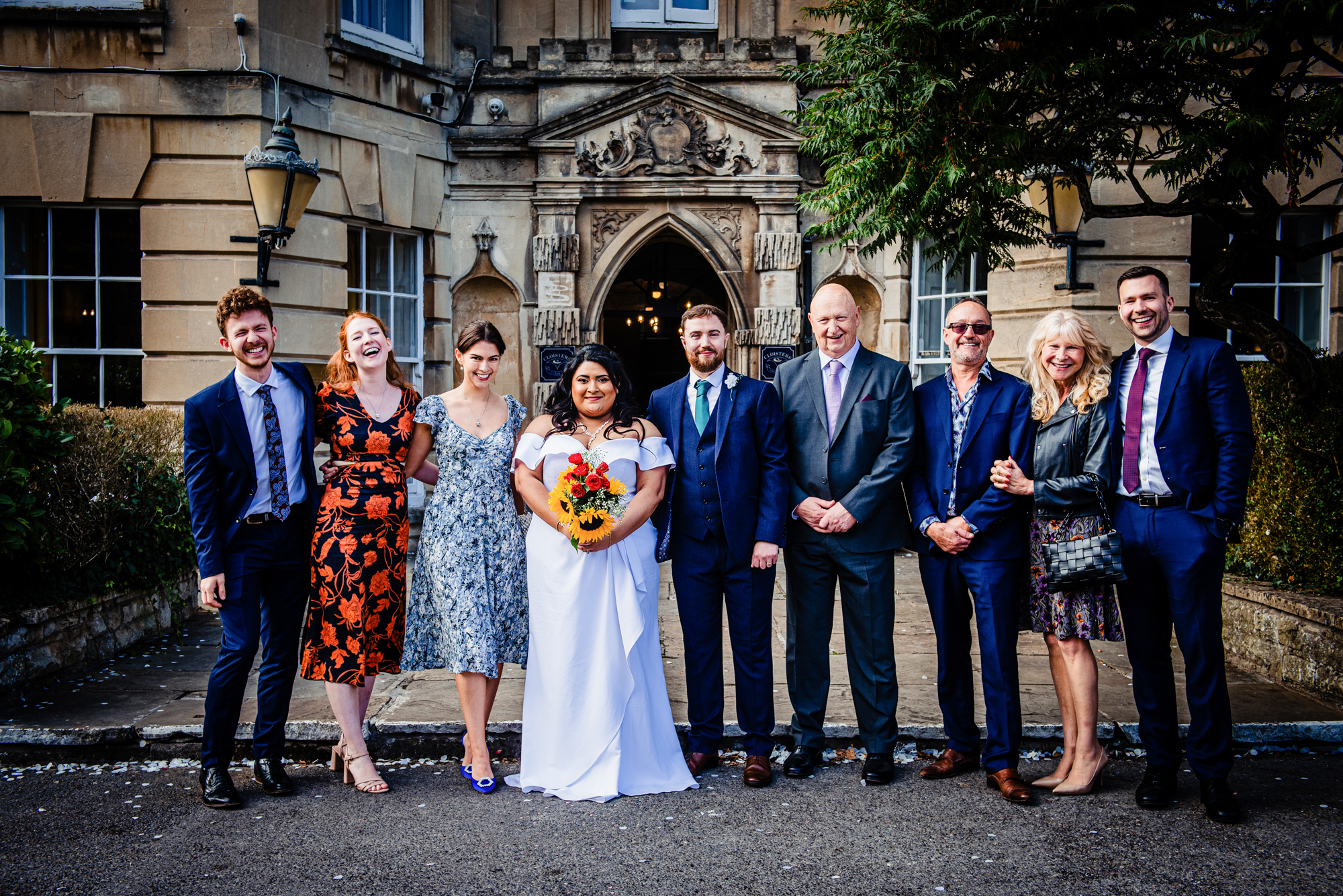 Couple standing with close family members outside Arnos Manor Hotel wedding venue.