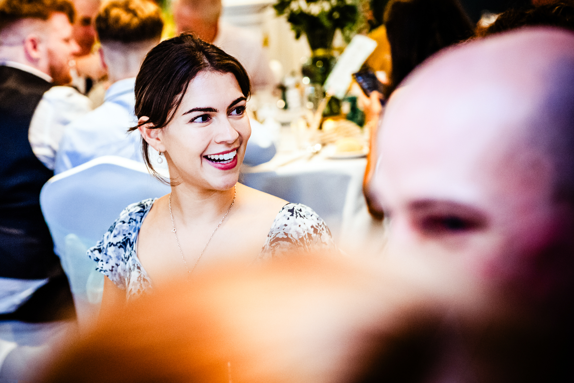 Wedding guest smiling during dinner reception at Arnos Manor Hotel.