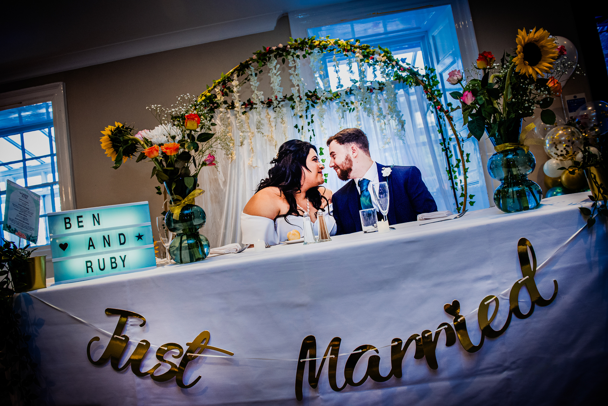 Bride and groom sharing a quiet moment at wedding reception table.