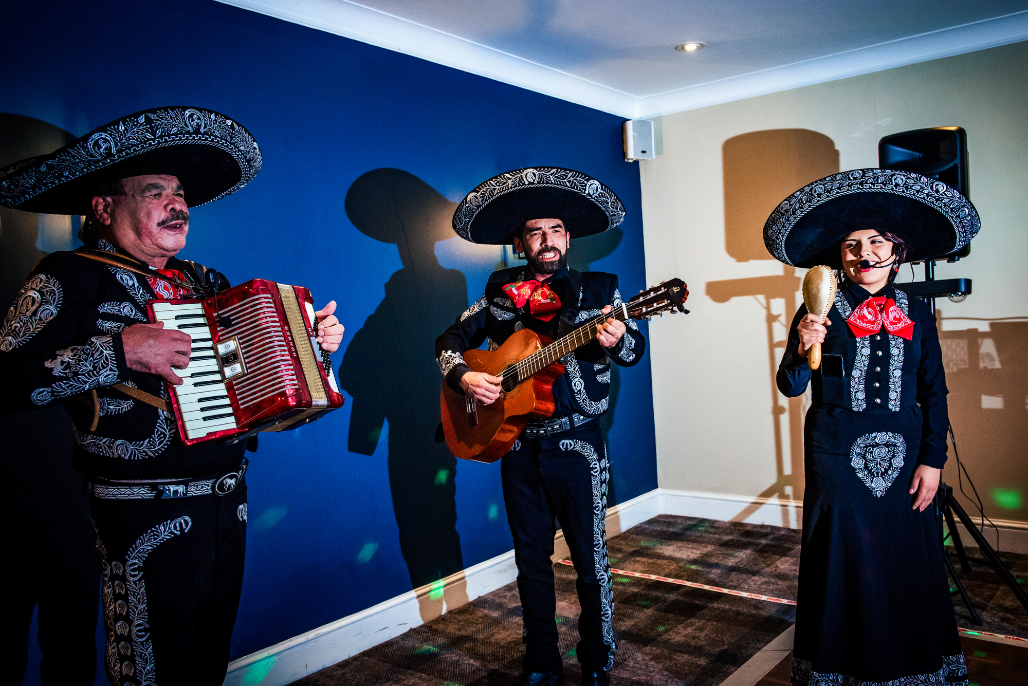 Mariachi band performing at wedding reception with traditional outfits.