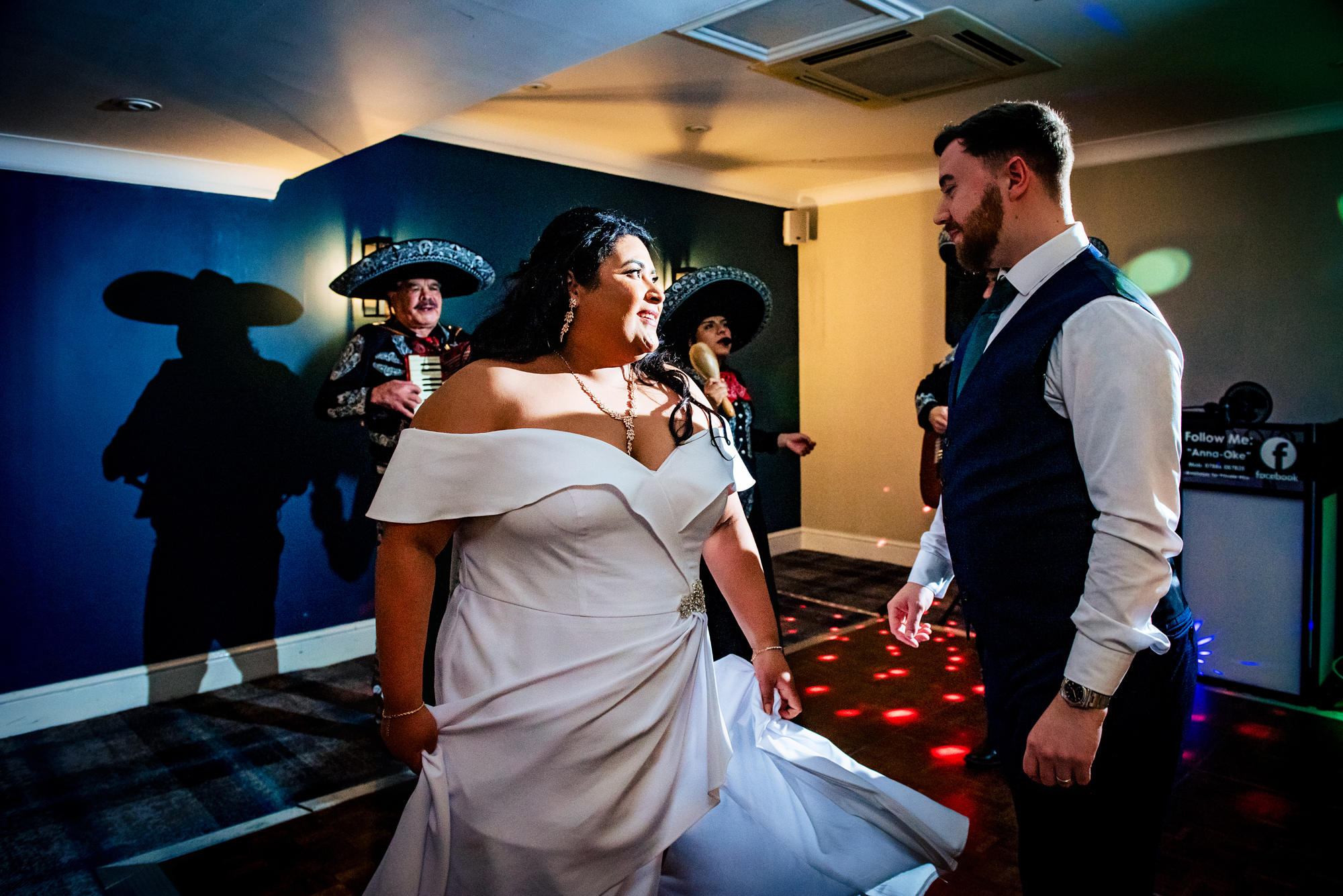 Bride and groom dancing together as mariachi band performs behind them at Arnos Manor Hotel at their wedding.