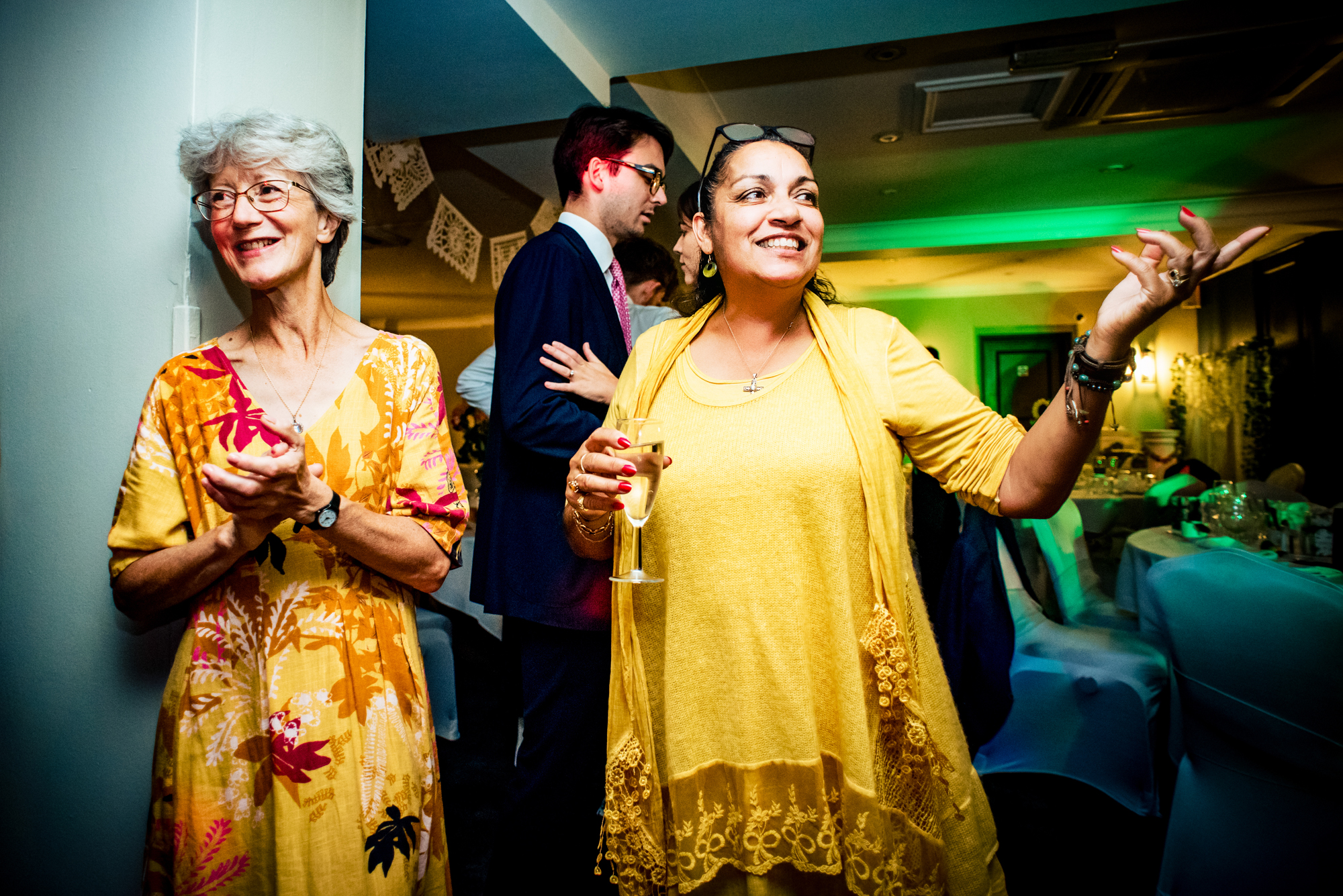 Guests chatting and celebrating with drinks during relaxed wedding reception moment.