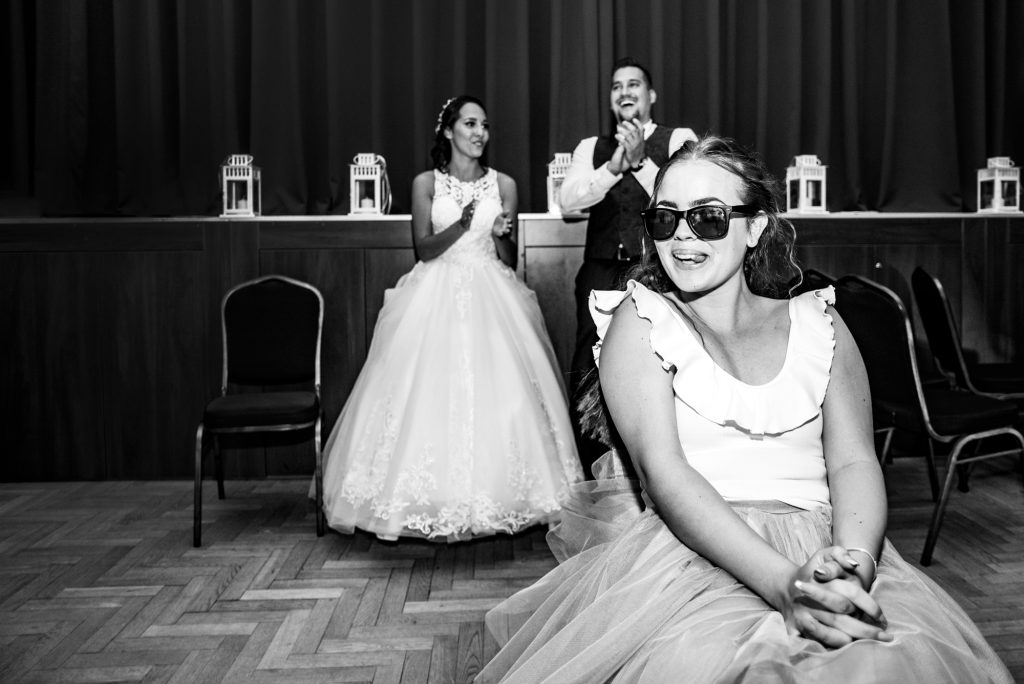 Bride and guest laughing during wedding game moment at Hungarian village reception.