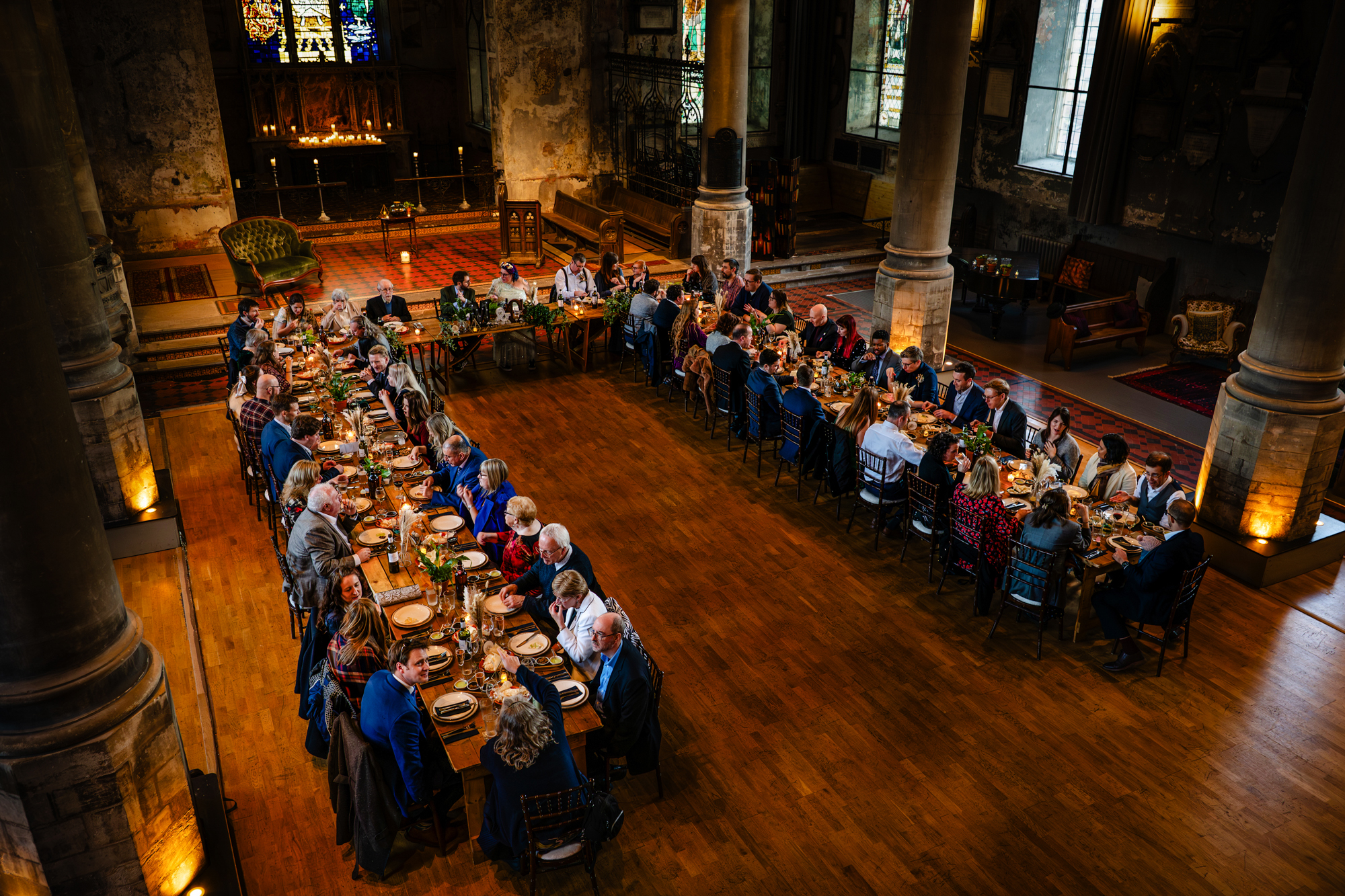 Long tables of guests enjoying wedding breakfast inside The Mount Without Bristol historic venue.
