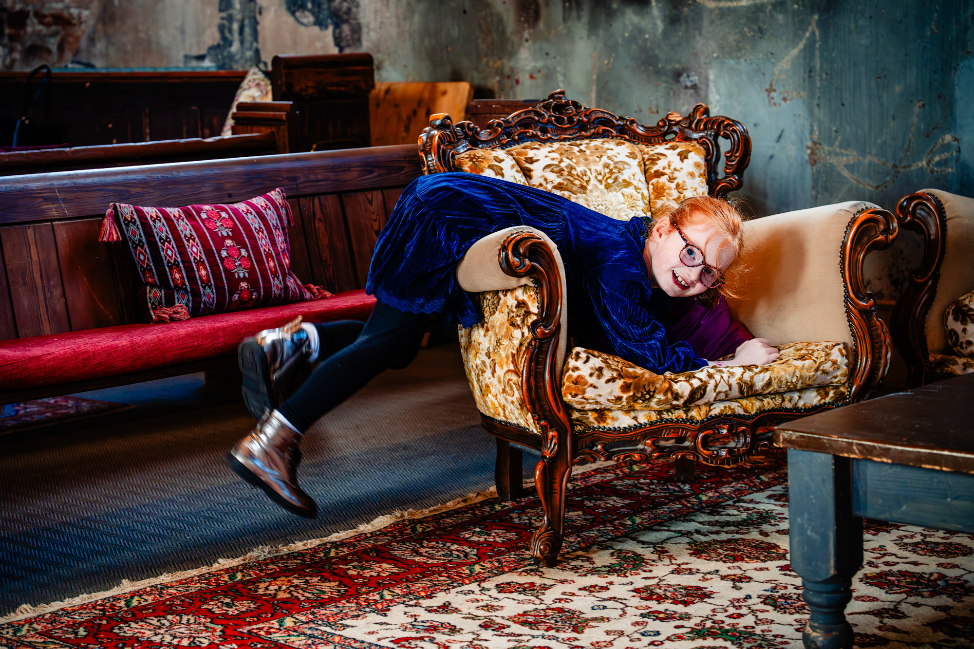 Child playing on vintage sofa during relaxed Mount Without Bristol wedding reception.