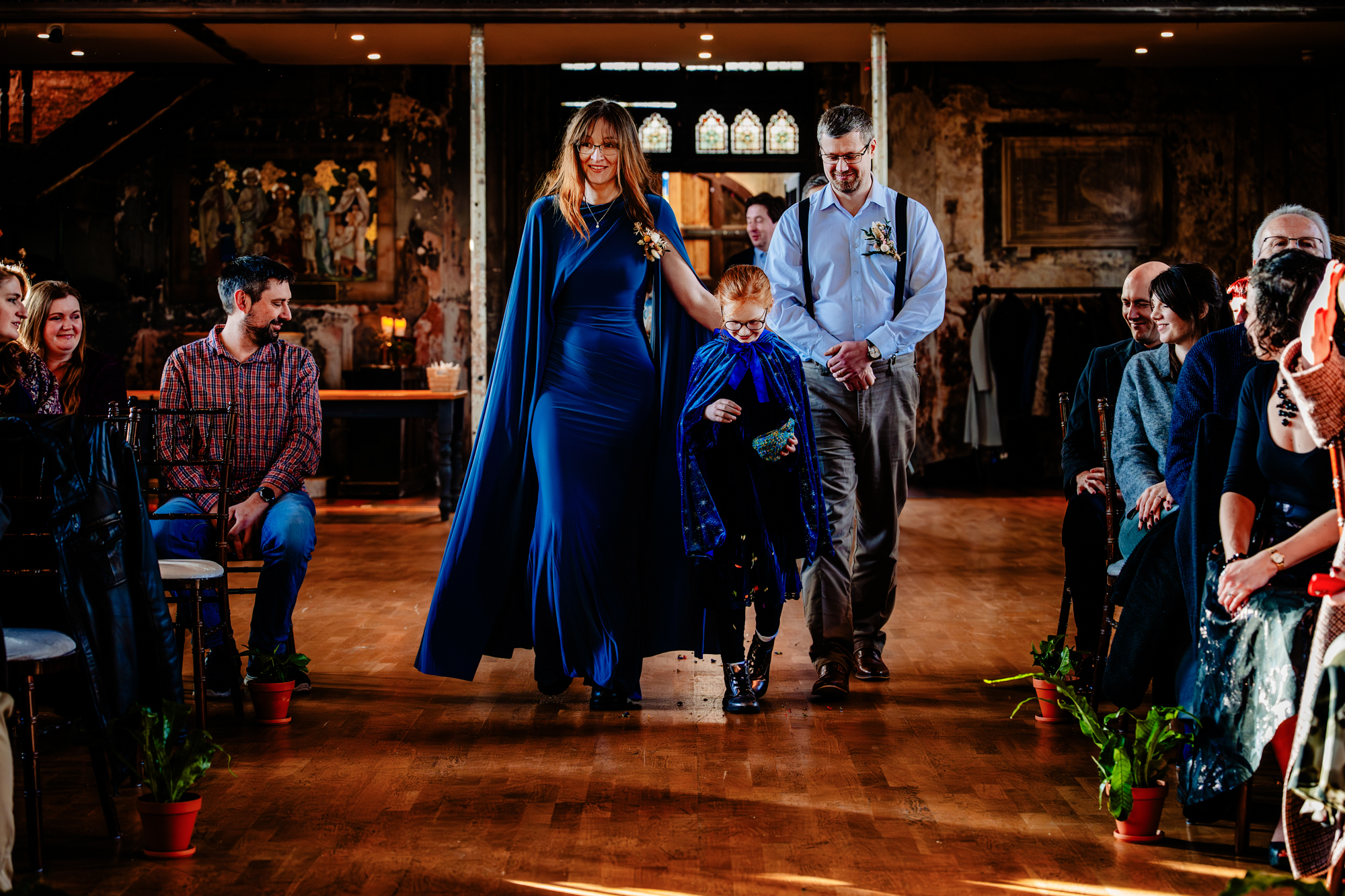 Parents and child walking down aisle during relaxed Bristol wedding ceremony.