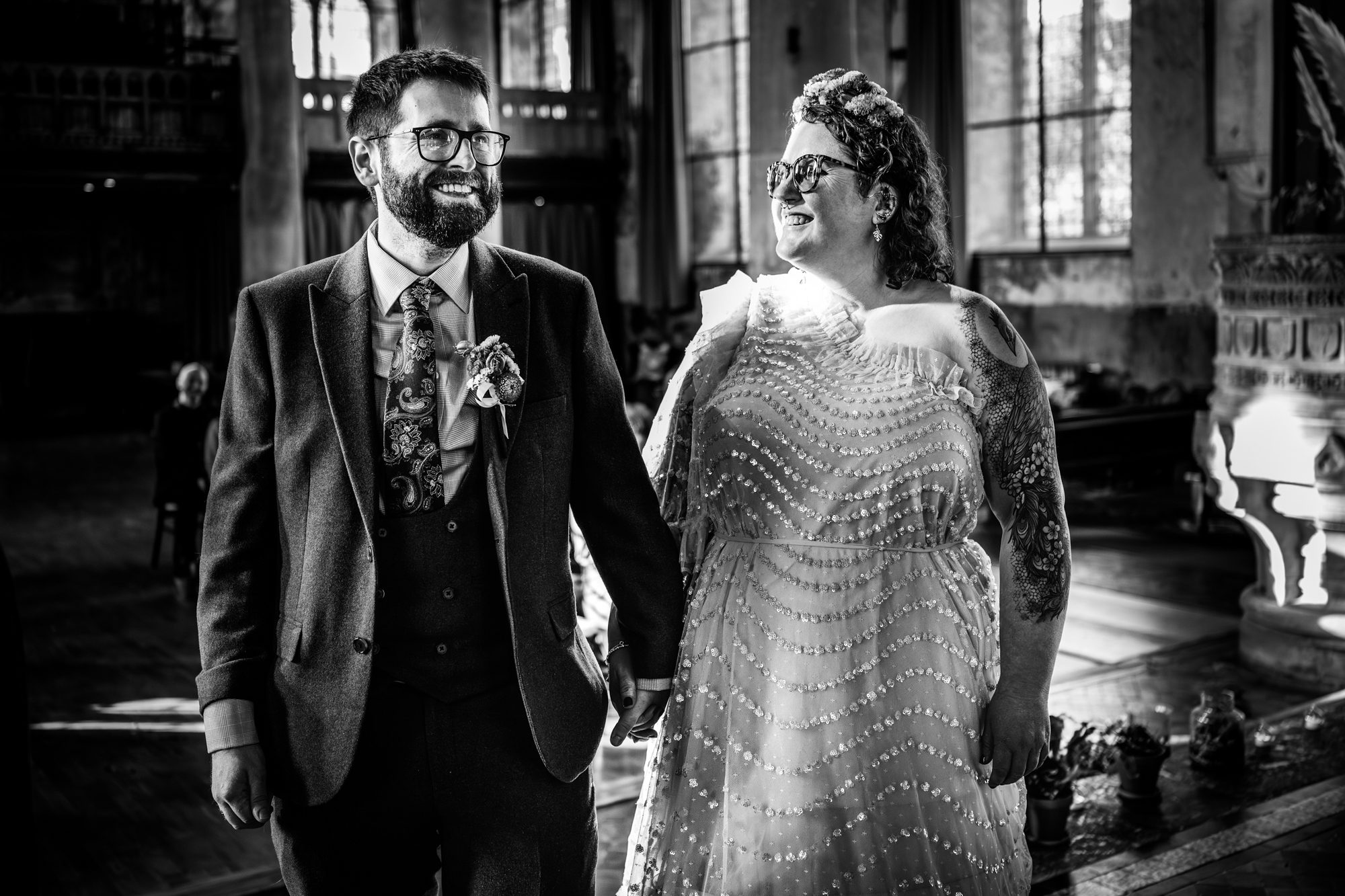 Black and white candid of couple smiling during ceremony.