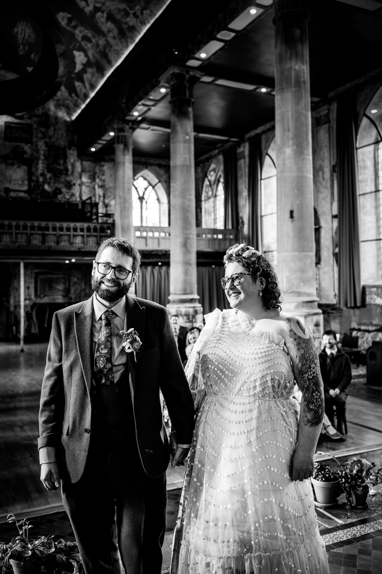 Couple smiling together during wedding ceremony in black and white inside historic Bristol venue.