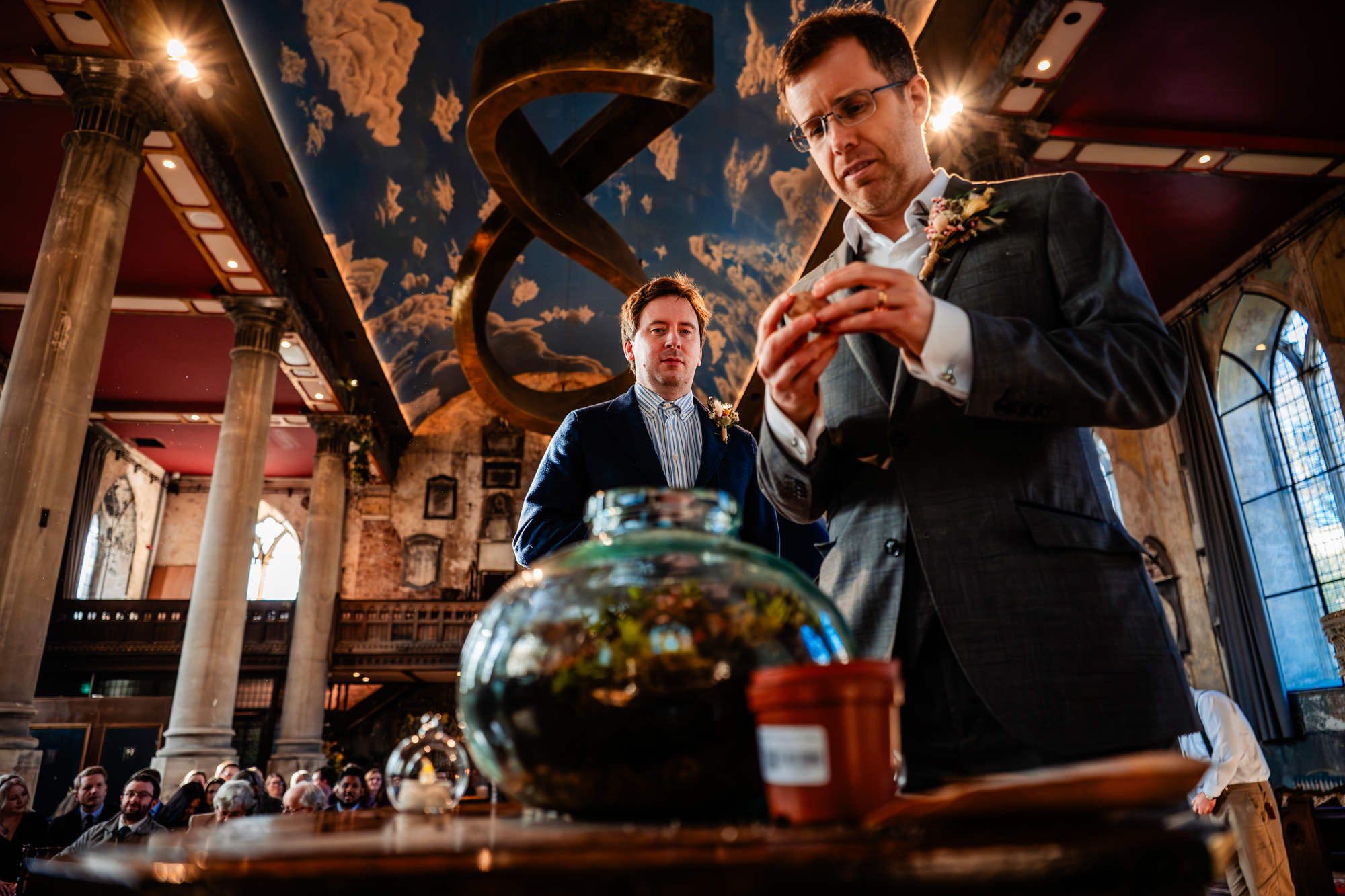 Wedding ceremony guests are building a terrarium for the couple