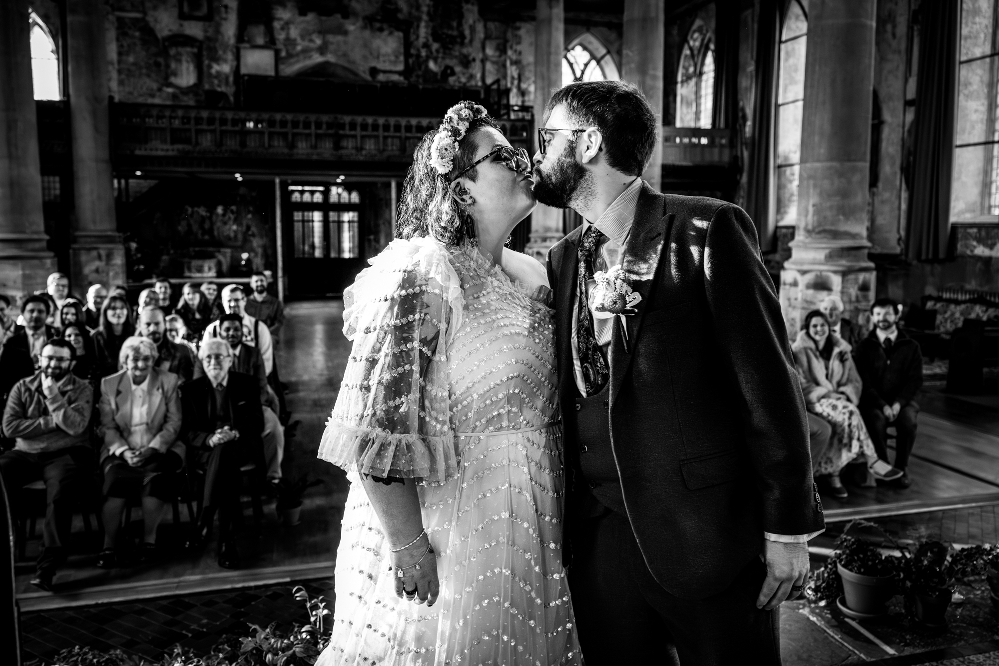 Black and white kiss during wedding ceremony inside The Mount Without Bristol.