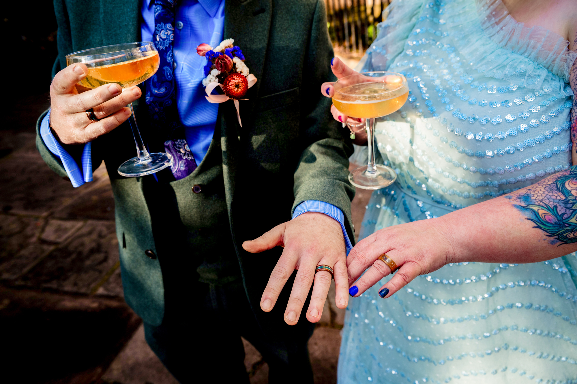 Close-up of wedding rings and champagne glasses during reception in Bristol.