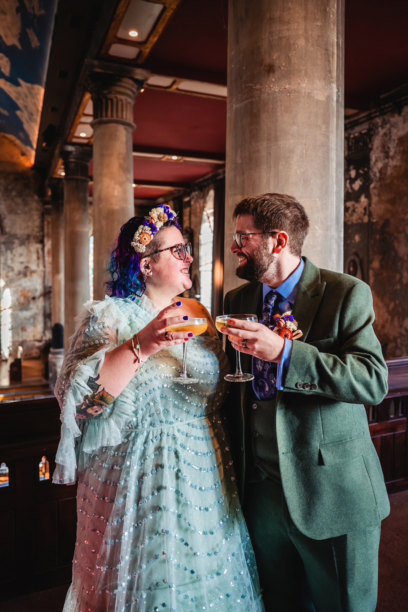 Couple celebrating with drinks inside The Mount Without Bristol wedding venue.